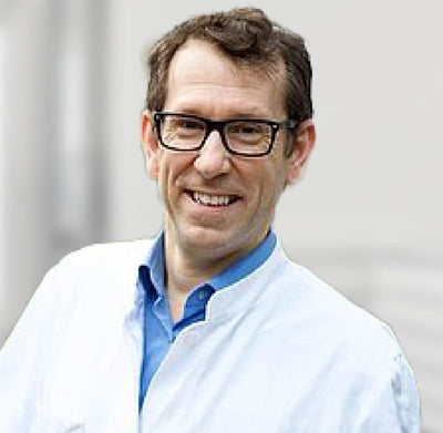 
Een glimlachende, professionele man met een bril
